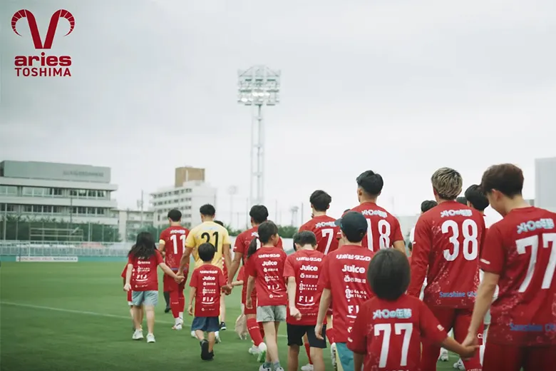 子供たちと手をつないで入場するエリース豊島FCの選手